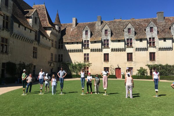 Personnes effectuant une activité Team Buiding dans la cour d'un château en Dordogne