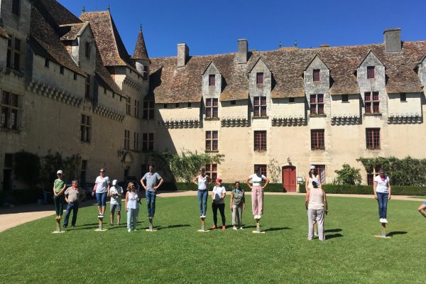 Personnes effectuant une activité Team Buiding dans la cour d'un château en Dordogne